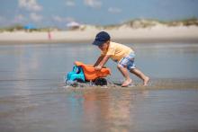 A boy plays with a toy truck on Holden Beach