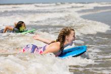 two girls boogie board on holden beach