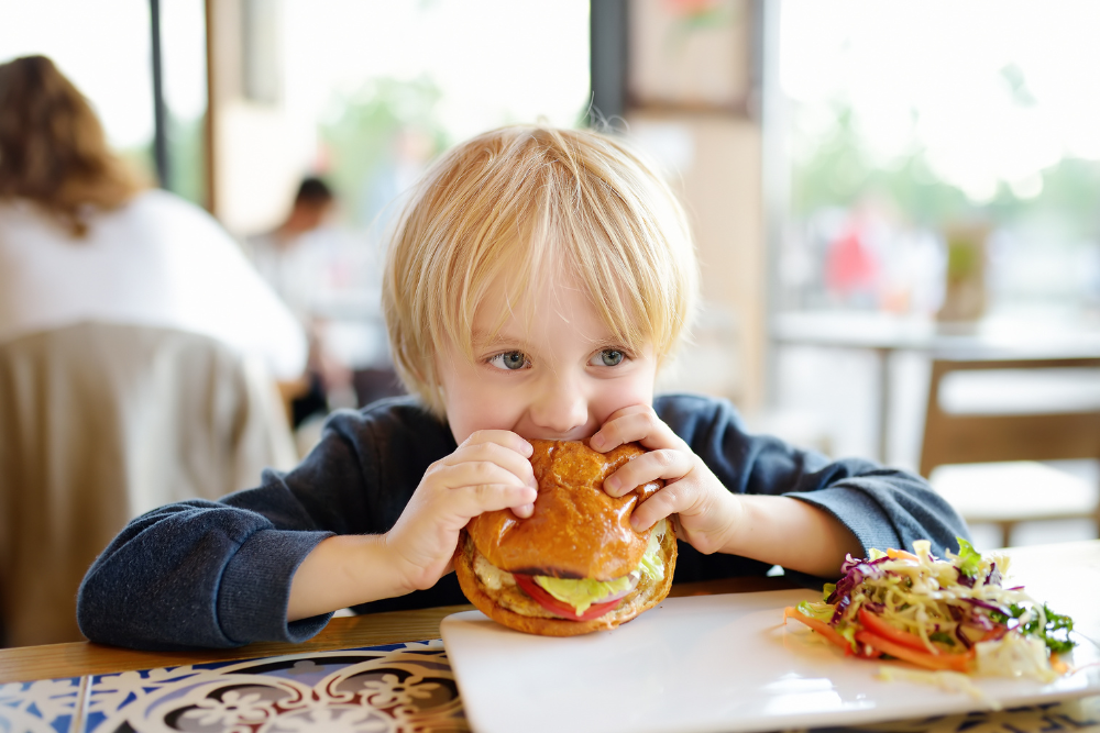 child eating hamburger