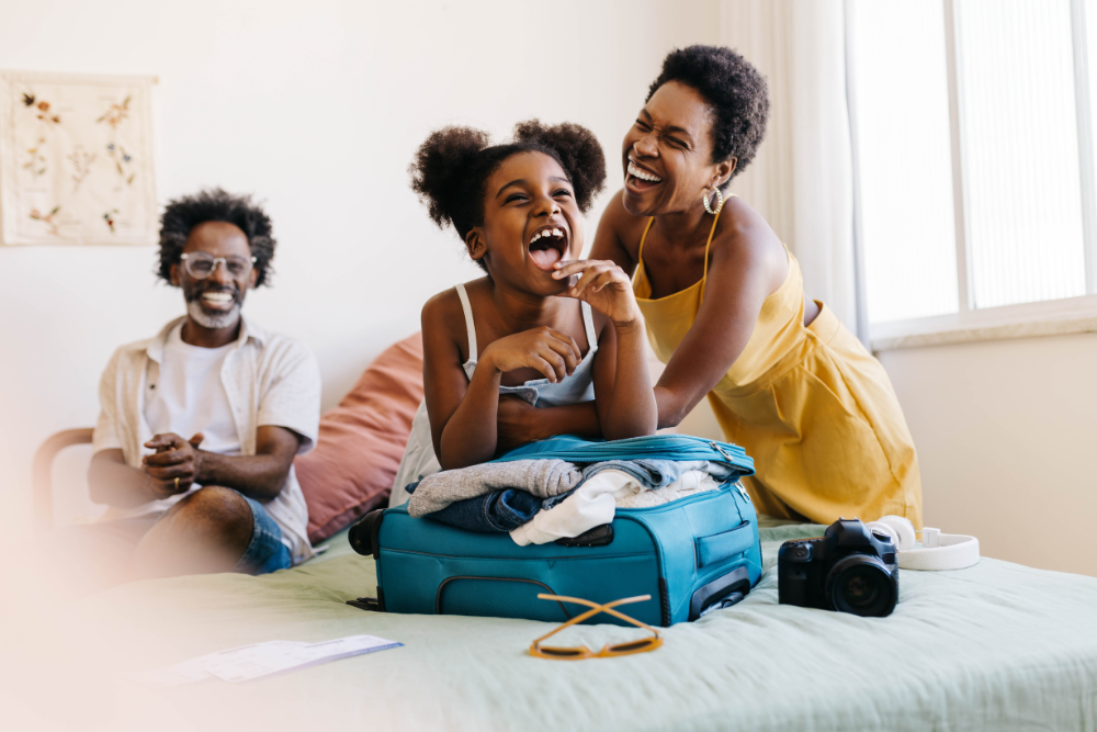 family packing suitcase on bed