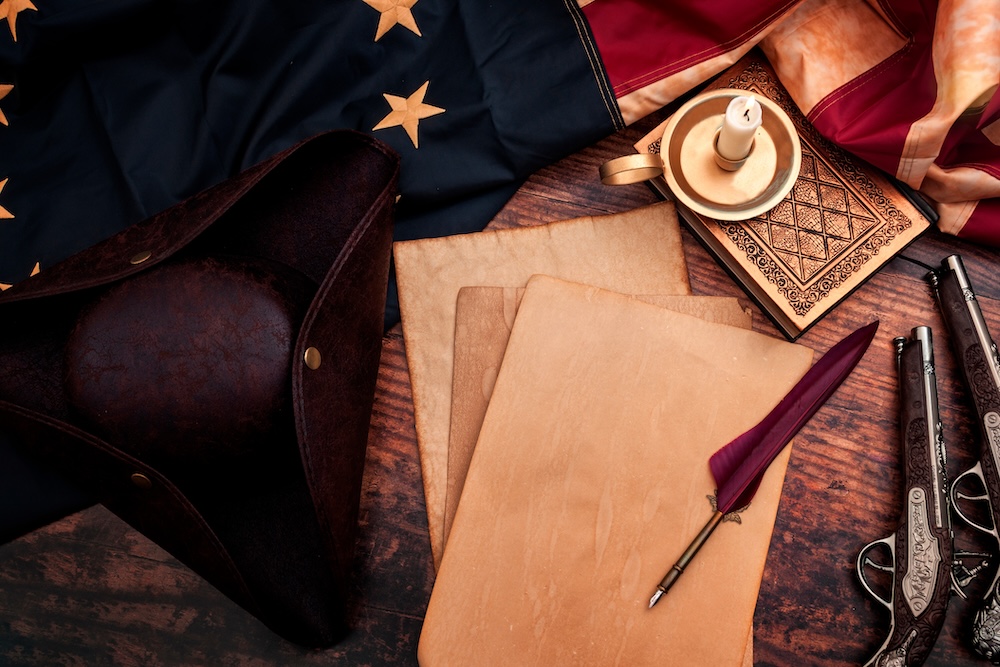 American Colonial Document and hat with flag on Wooden Desk